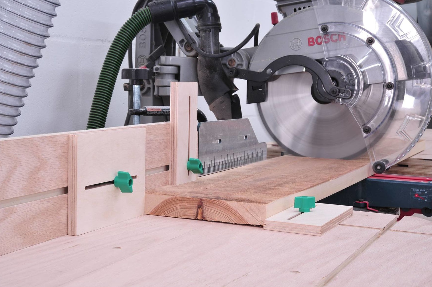 Workshop setup with saw accessories and green hardware screws securing wooden jigs for woodworking and home improvement projects