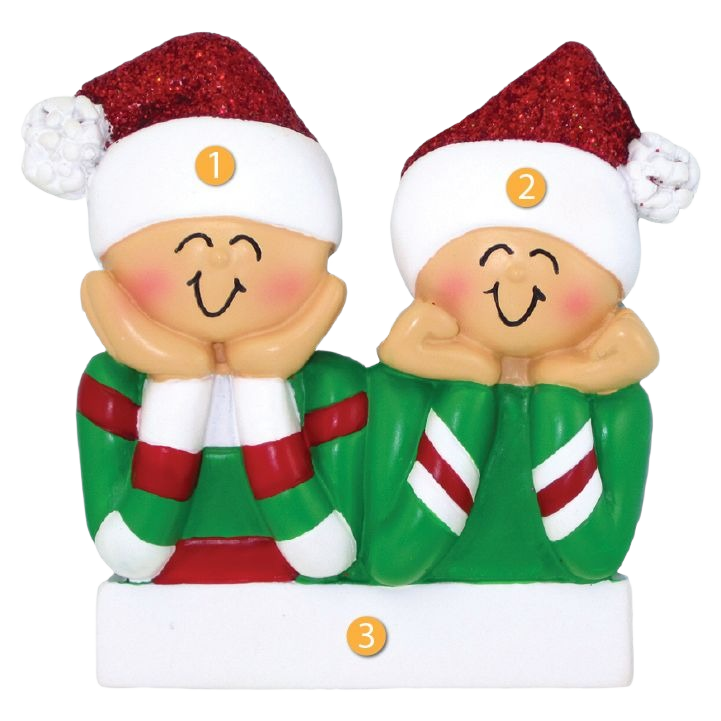 Festive holiday ornament of two smiling figures in red and green sweaters with glittery Santa hats from Christmas collection