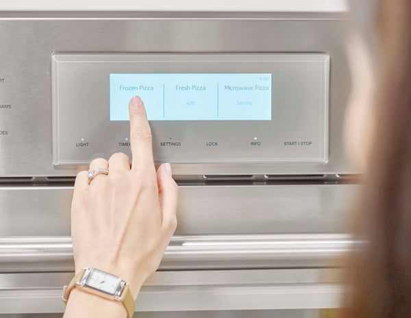User selecting frozen pizza option on stainless steel speed oven touchscreen panel in Microwaves collection