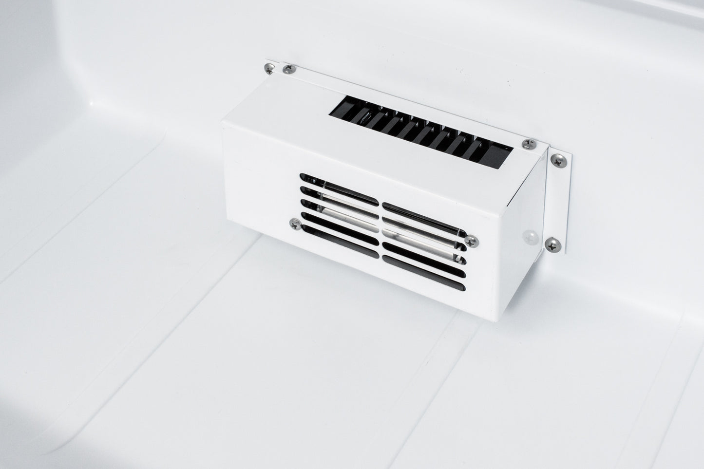 Close-up of white interior vent and air circulation grille designed for efficient cooling in ADA-compliant refrigerator unit