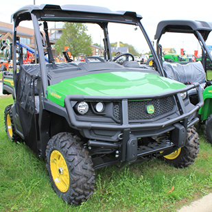 Green full-size utility vehicle with brush guard and rugged tires designed for outdoor and home improvement use