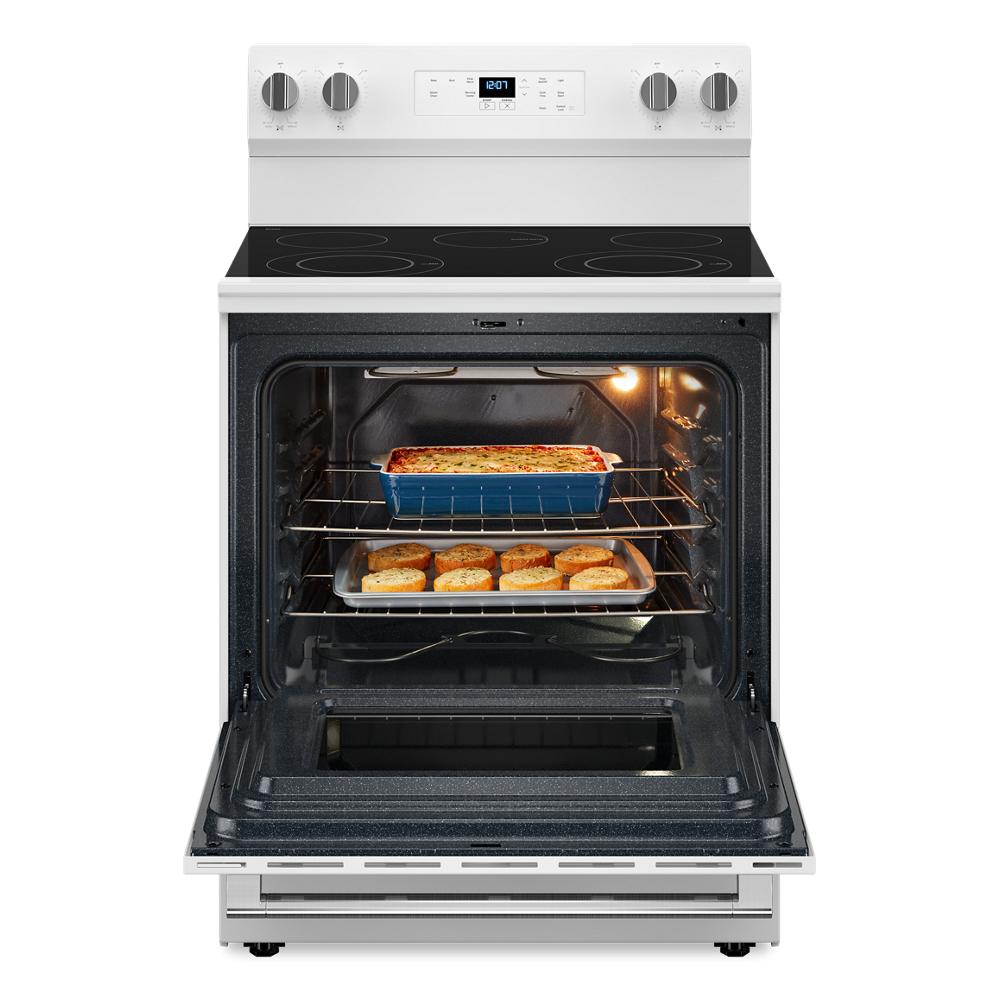 White electric range with ceramic glass cooktop and open oven baking casserole and biscuits in kitchen setting