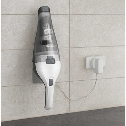 Compact white cordless handheld vacuum mounted on wall with charging cable plugged in for home cleaning tasks