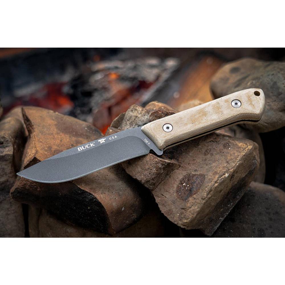 Fixed blade knife with natural canvas Micarta handle resting on rocks for cutting and woodworking hand tools collection