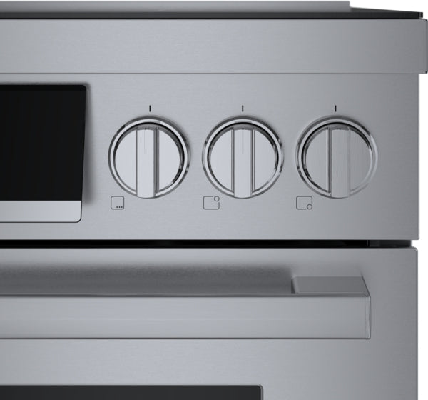 Close-up of stainless steel induction range control panel with three metal knobs and sleek handle from Bosch collection