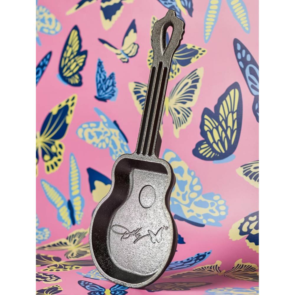 Mini cast iron skillet shaped like a guitar with engraved signature detail on a colorful butterfly background