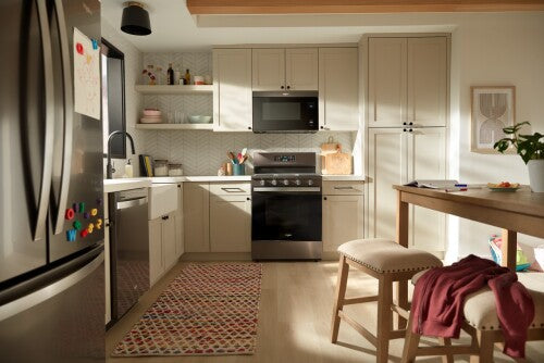 Modern kitchen with beige cabinetry, stainless steel refrigerator and dishwasher, and a black gas range in cooking appliances collection