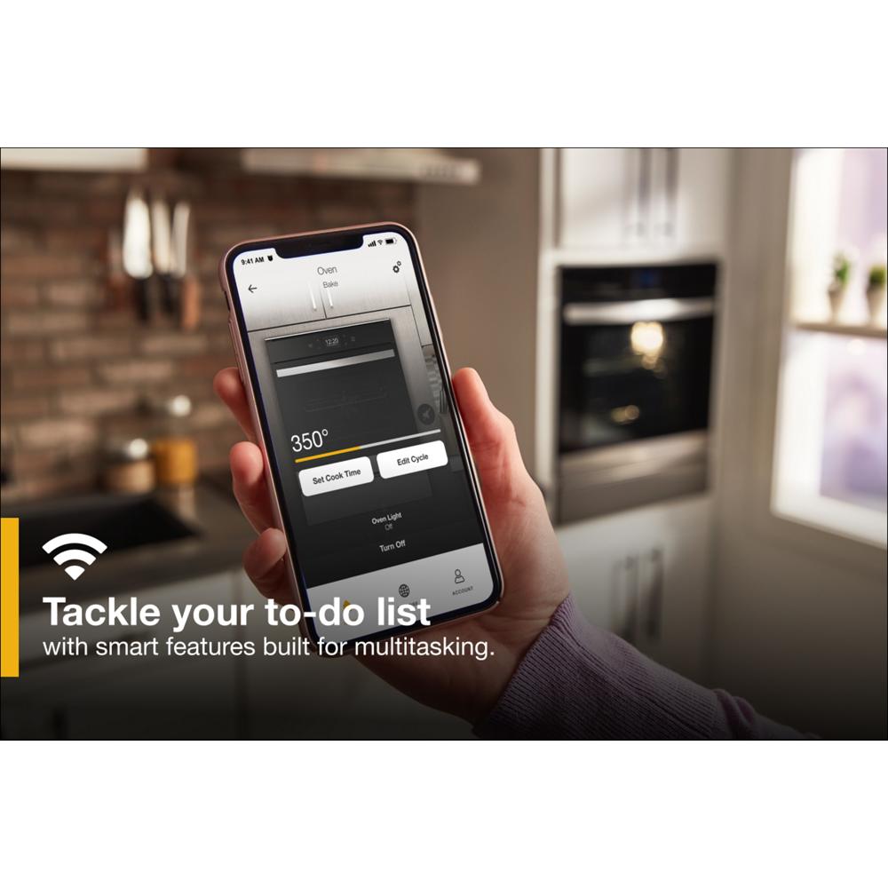Hand holding smartphone showing oven control app with double wall oven in background from Kitchen & Kitchenware collection