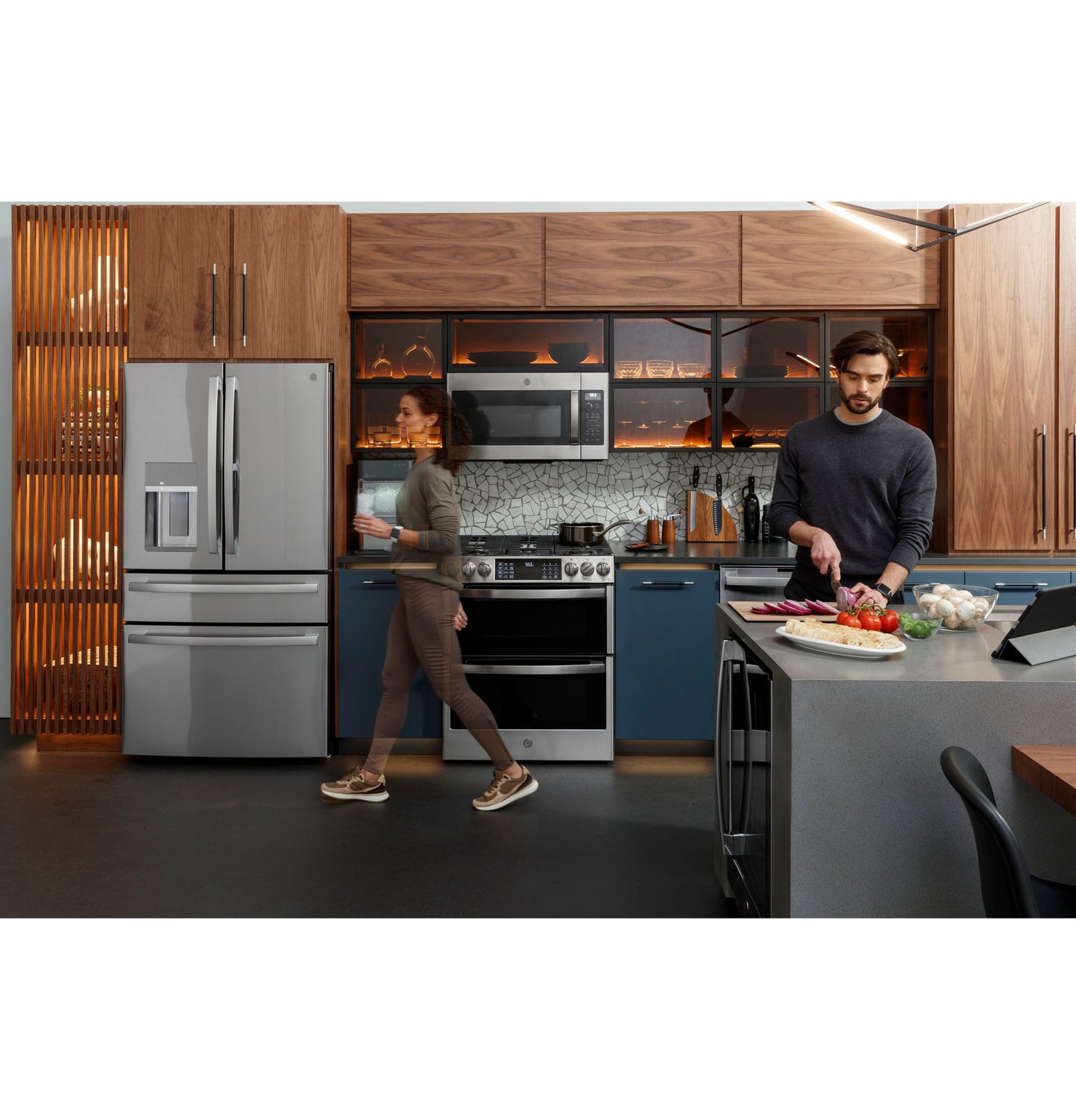 Modern kitchen with fingerprint-resistant double oven gas range, stainless steel fridge, and blue lower cabinetry from Ranges collection