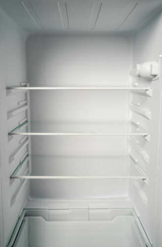 Empty refrigerator interior with three adjustable glass shelves and clear plastic drawers, part of kitchen appliances collection