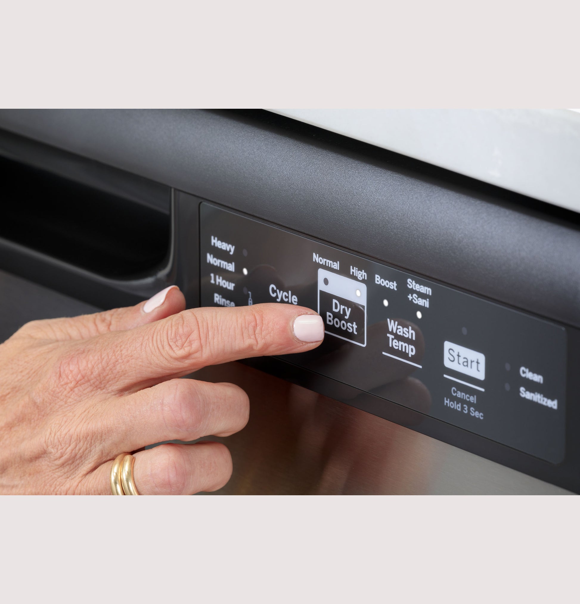 Hand pressing Dry Boost button on front control panel of stainless steel dishwasher from appliances collection