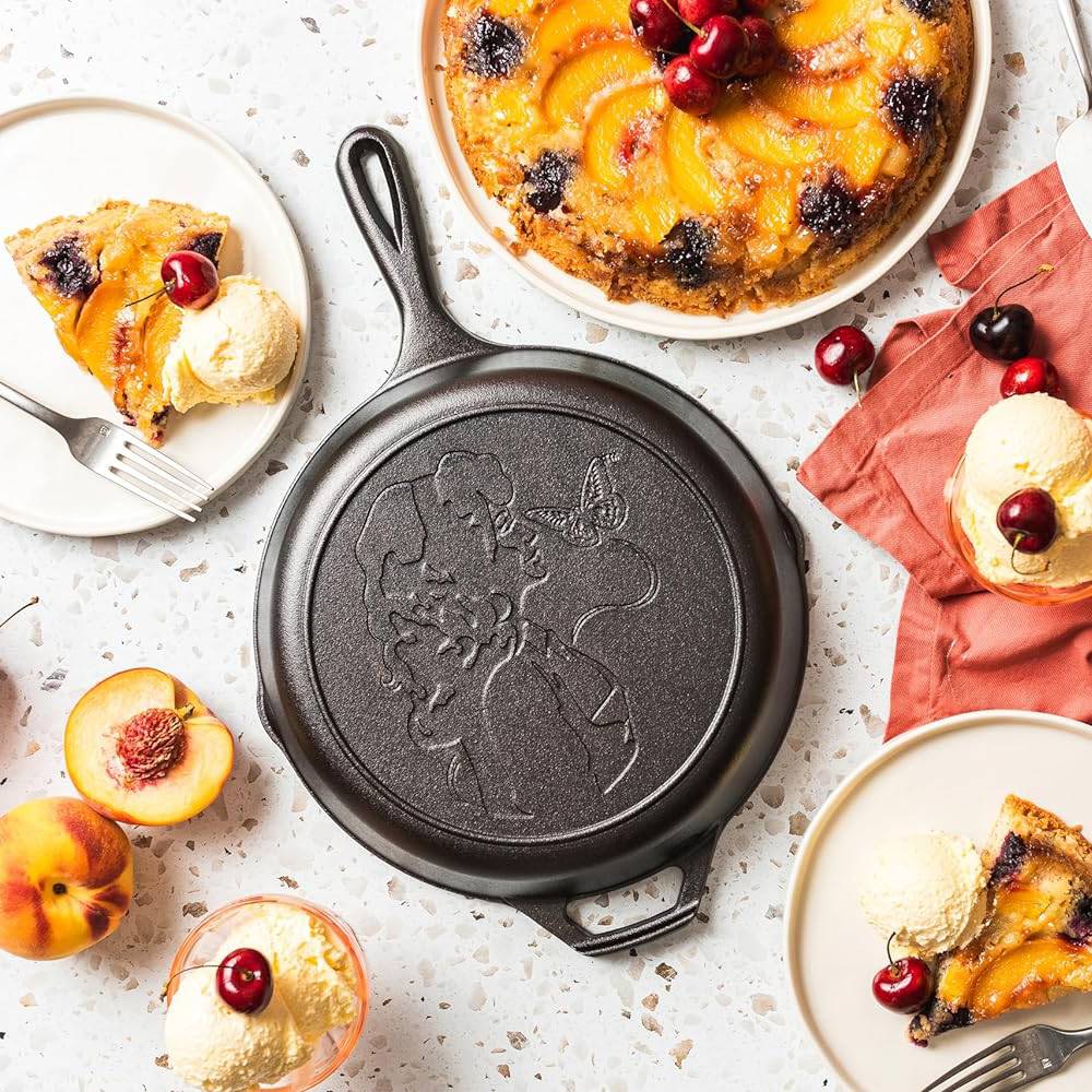 Cast iron skillet with embossed figure and butterfly, surrounded by peach dessert slices with ice cream, under $100 kitchenware collection