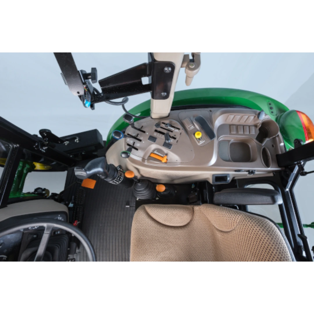 Interior view of green utility tractor cab focusing on control panel, levers, and beige fabric operator seat