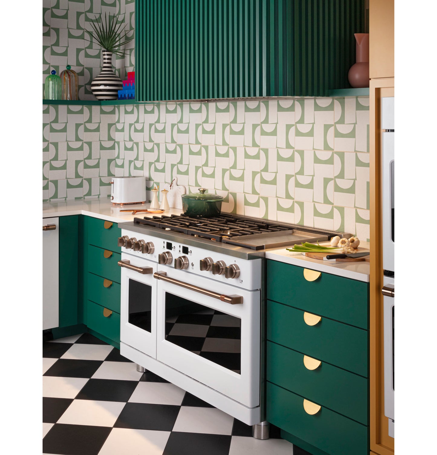 Contemporary kitchen featuring green cabinets, geometric backsplash, white range, and checkered black and white floor tiles