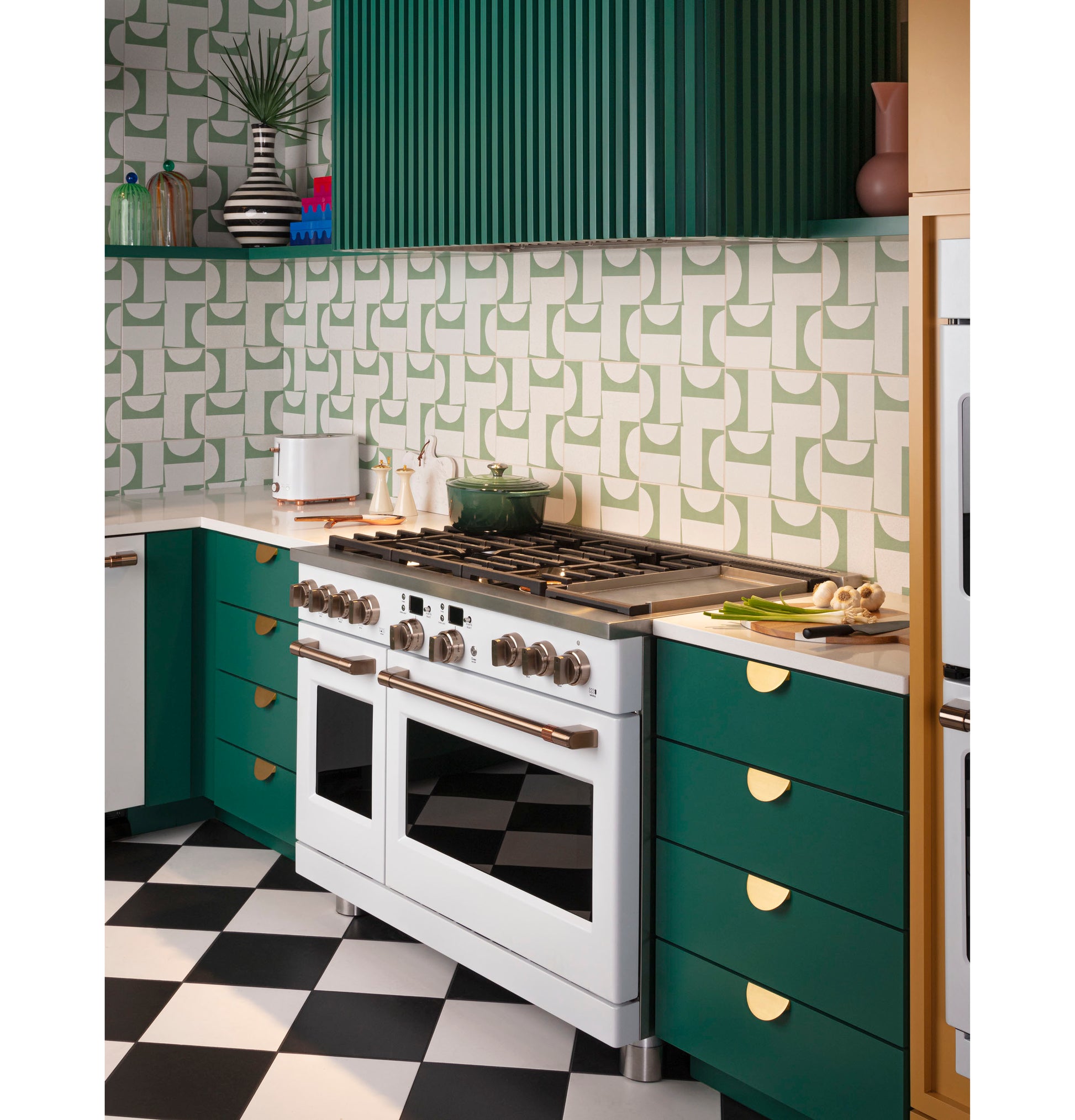 Contemporary kitchen featuring green cabinets, geometric backsplash, white range, and checkered black and white floor tiles