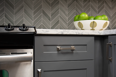 Modern satin nickel cabinet pull installed on dark gray kitchen drawer for home improvement projects