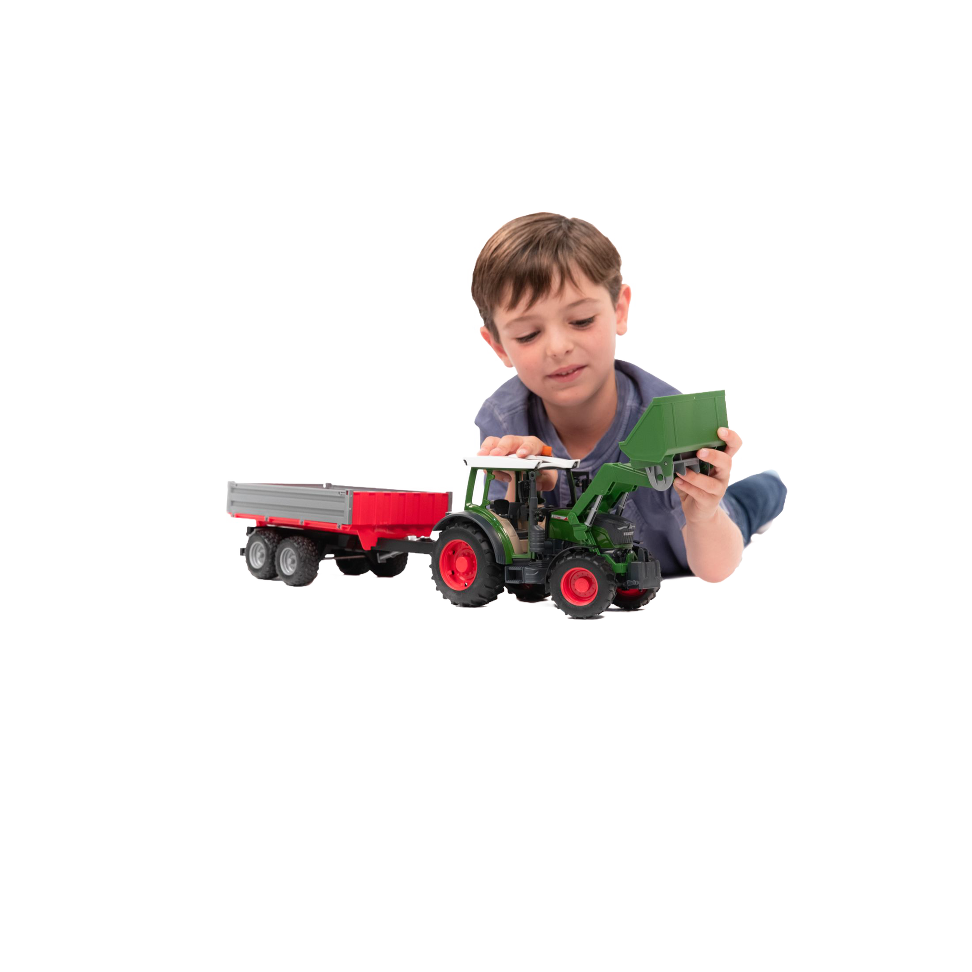 Young boy playing with a green tractor toy and red tipping trailer from Bruder Toys in Vehicles & Remote Controlled Toys collection