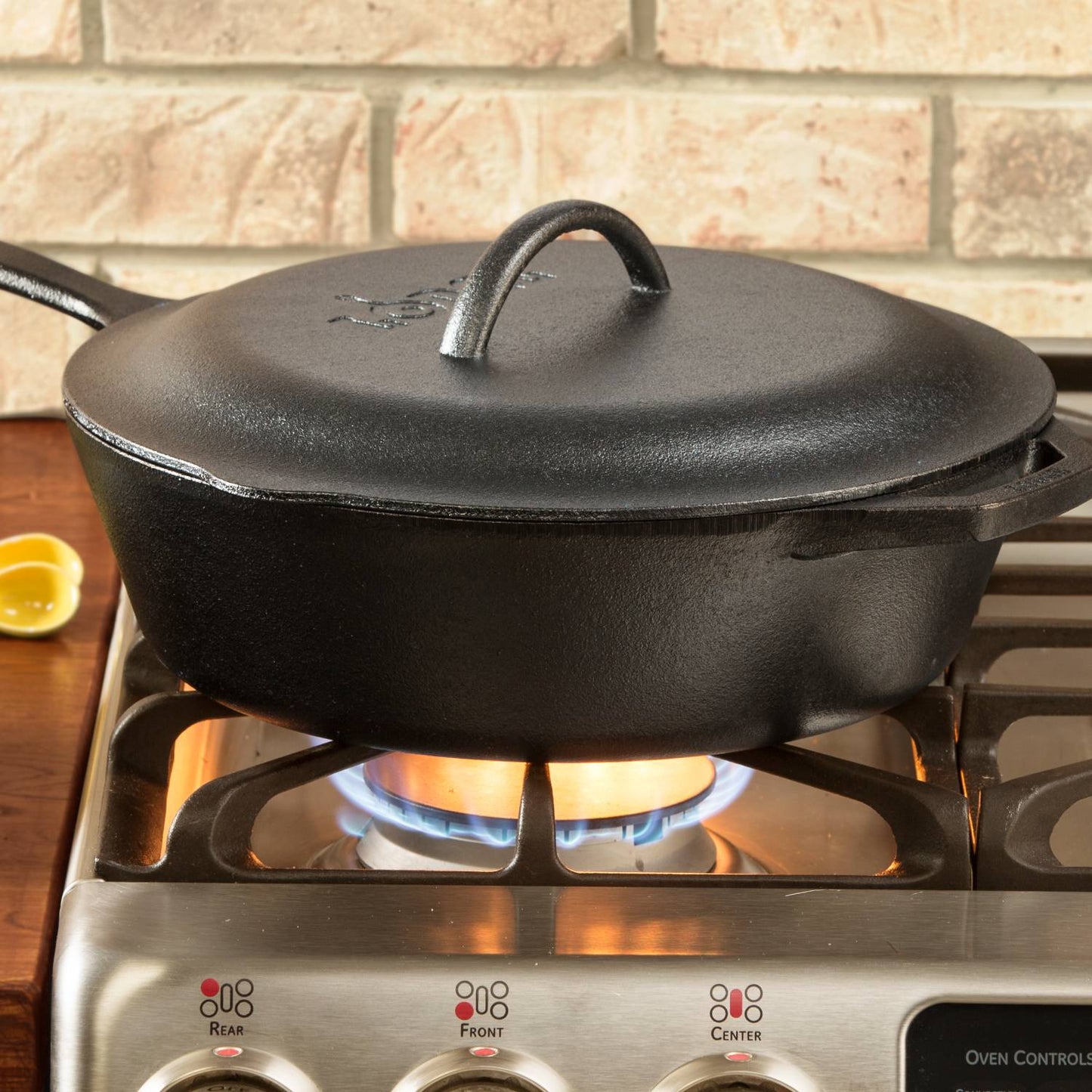 Extra deep black cast iron chicken fryer with lid and handle on gas stove from Lodge Cast Iron kitchenware under $100 collection