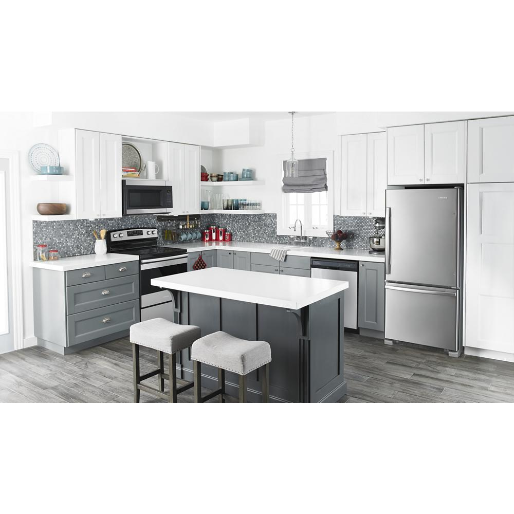 Modern kitchen with gray cabinets, white countertops, stainless steel bottom freezer refrigerator, and island with stools
