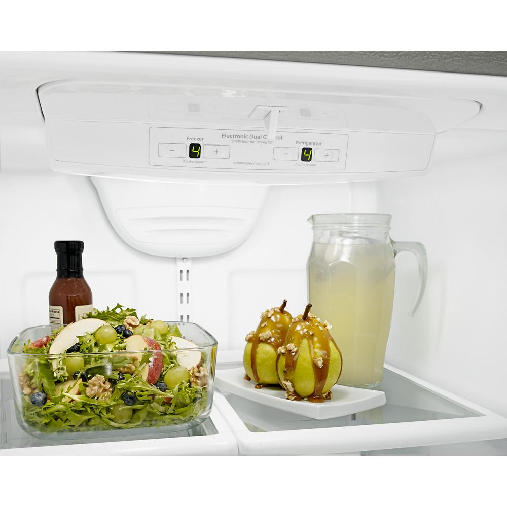 Inside view of refrigerator with digital controls showing fresh salad, pears, drink pitcher, and bottled dressing on glass shelves
