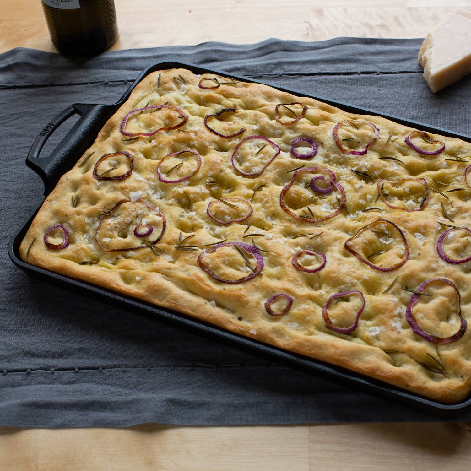 Rectangular pre-seasoned cast iron baking pan with focaccia topped with red onions for kitchenware under $100 collections