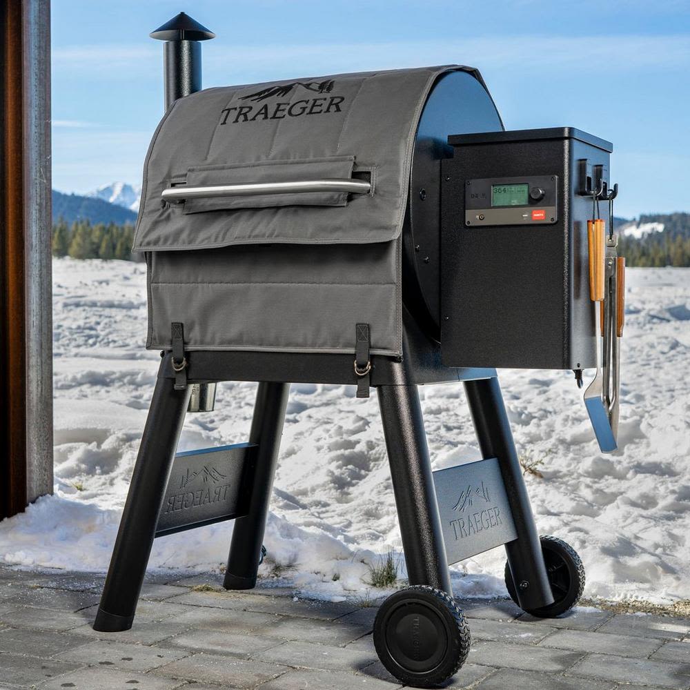 Gray insulated grill cover blanket fitted on Traeger Pro Series smoker for outdoor grilling and lawn care accessories