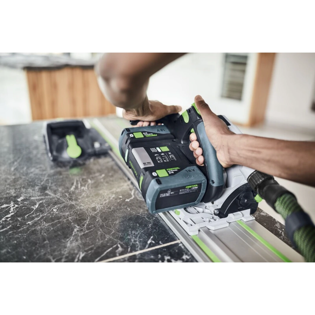 Person using Festool power tool with green accents and vacuum hose on cutting guide in woodworking tool accessories collection