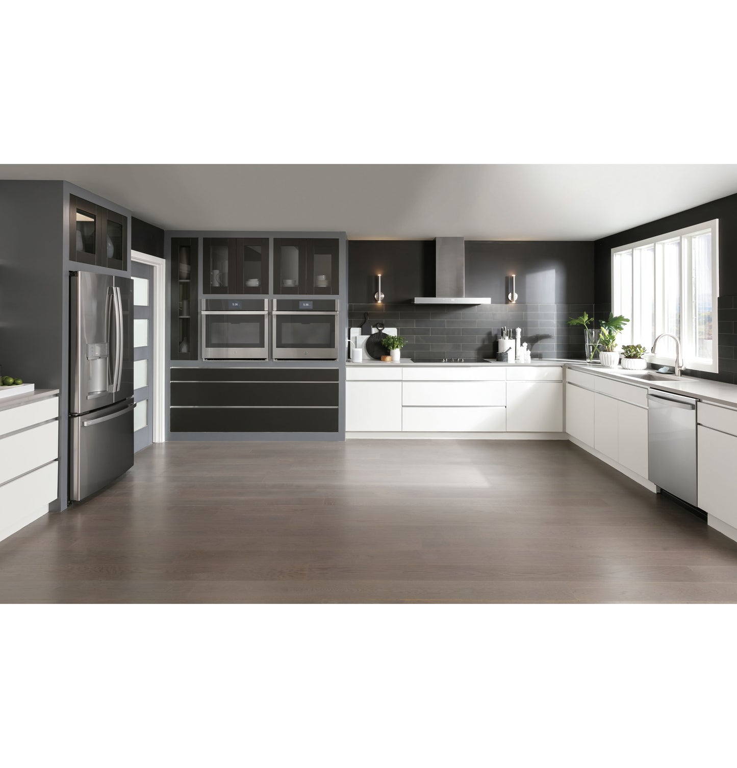 Contemporary kitchen with dark cabinetry, stainless steel appliances, and a smart wall mount hood over cooktop