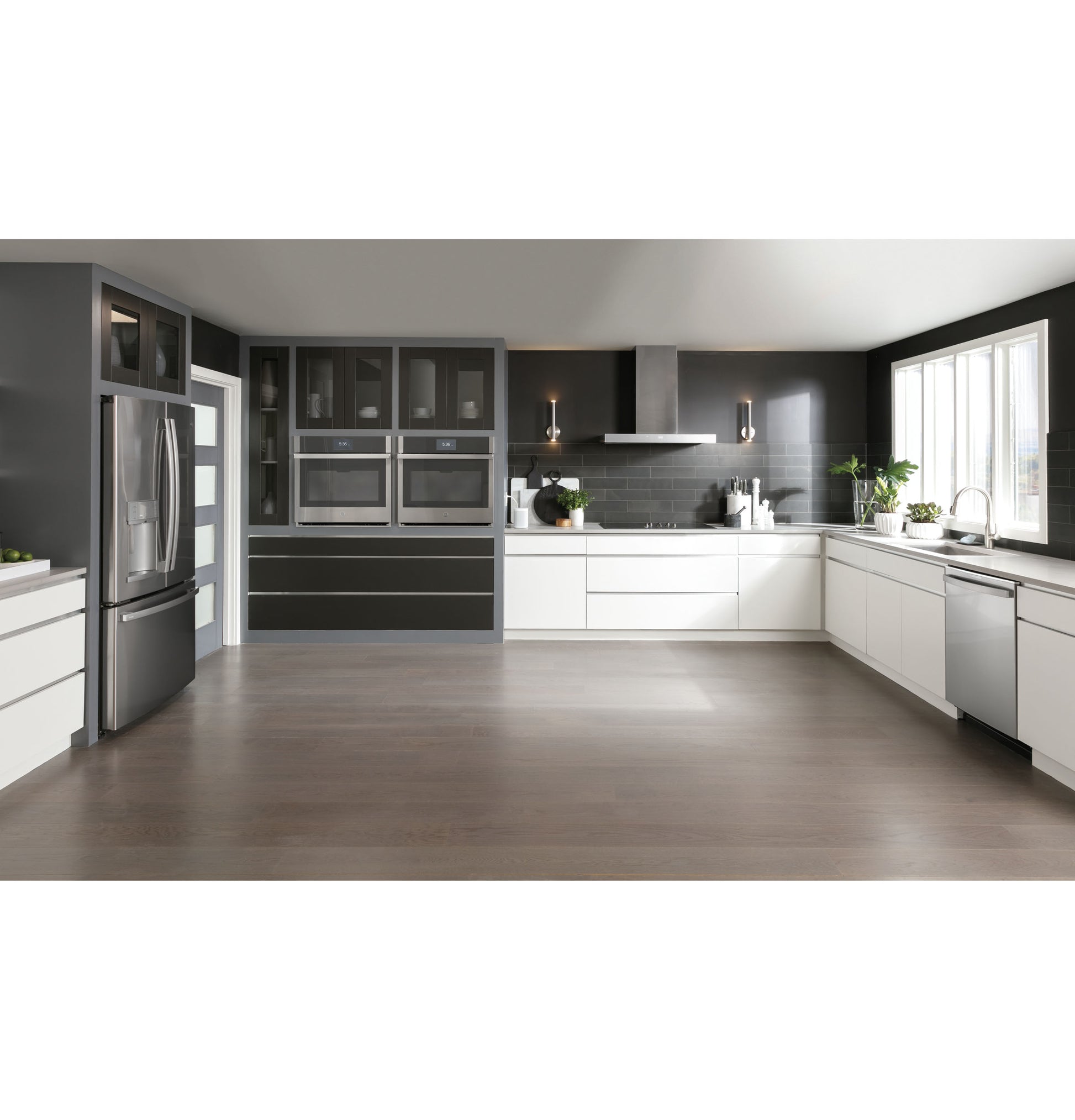 Contemporary kitchen with dark cabinetry, stainless steel appliances, and a smart wall mount hood over cooktop