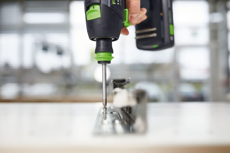 Green and black cordless driver installing a fastener with a Pozidrive bit for home improvement tasks