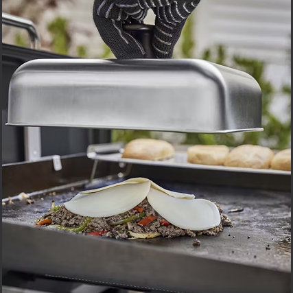 Stainless steel basting dome with black handle used for melting cheese on grilled food in outdoor cooking and grill accessories collections