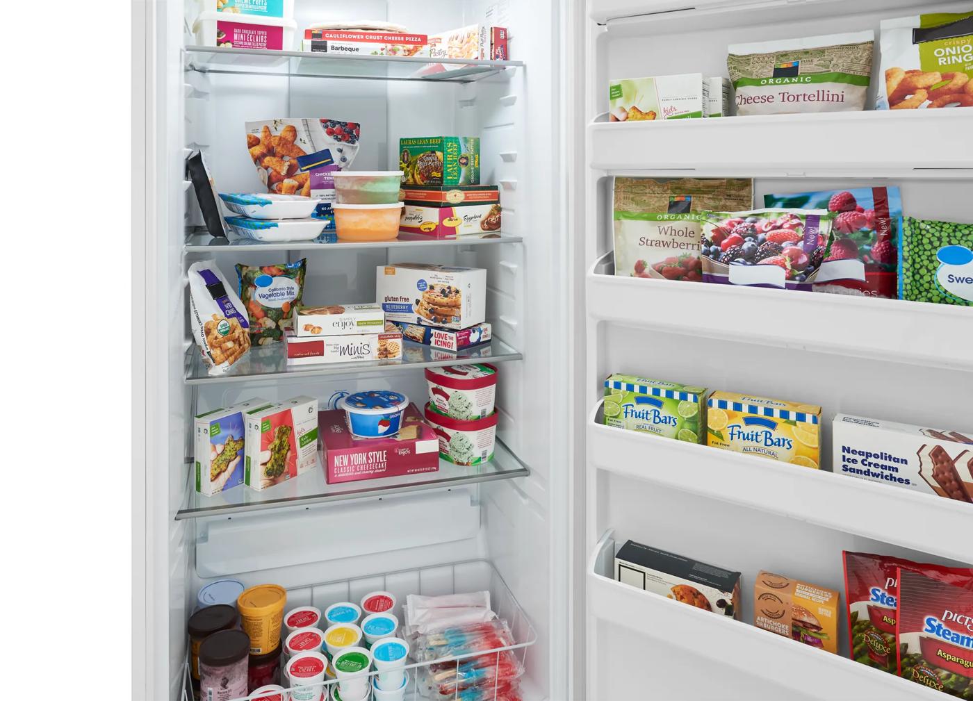 Interior view of upright freezer showing organized frozen foods on glass shelves and door bins from freezers collection