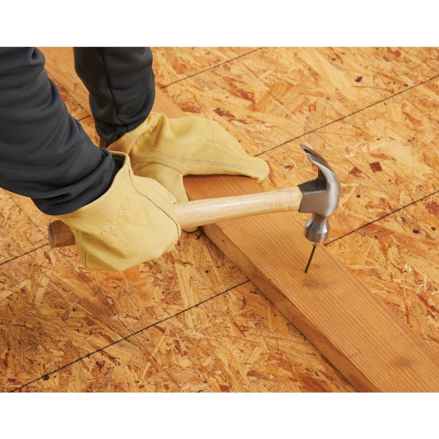 Worker wearing tan top grain cowhide leather gloves hammering a nail into wood for home improvement tasks