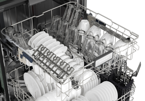 Open stainless steel dishwasher rack loaded with white dishes and clear glassware, part of kitchen appliances.