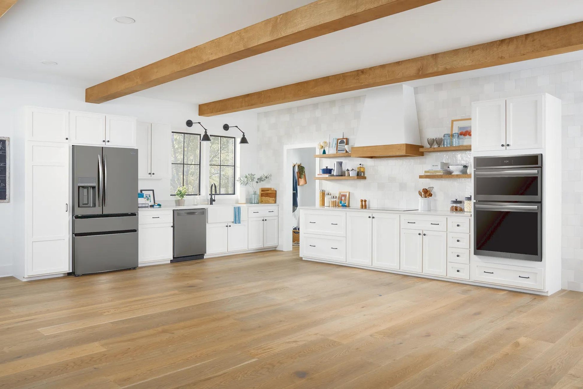 Modern kitchen featuring stainless steel 30" electric wall oven and microwave combo with white cabinetry and wood accents