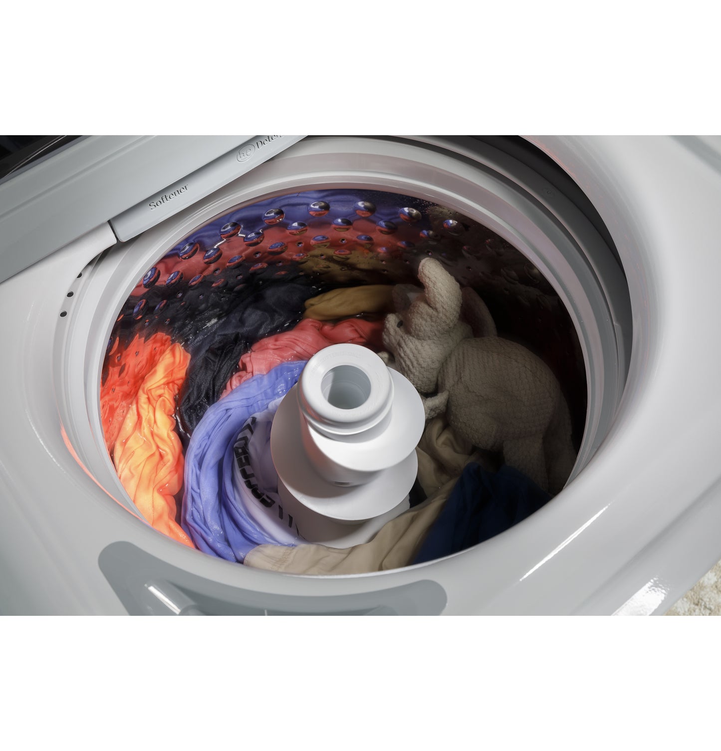 Top load washer drum filled with colorful laundry in stainless steel interior from Washers & Dryers collection
