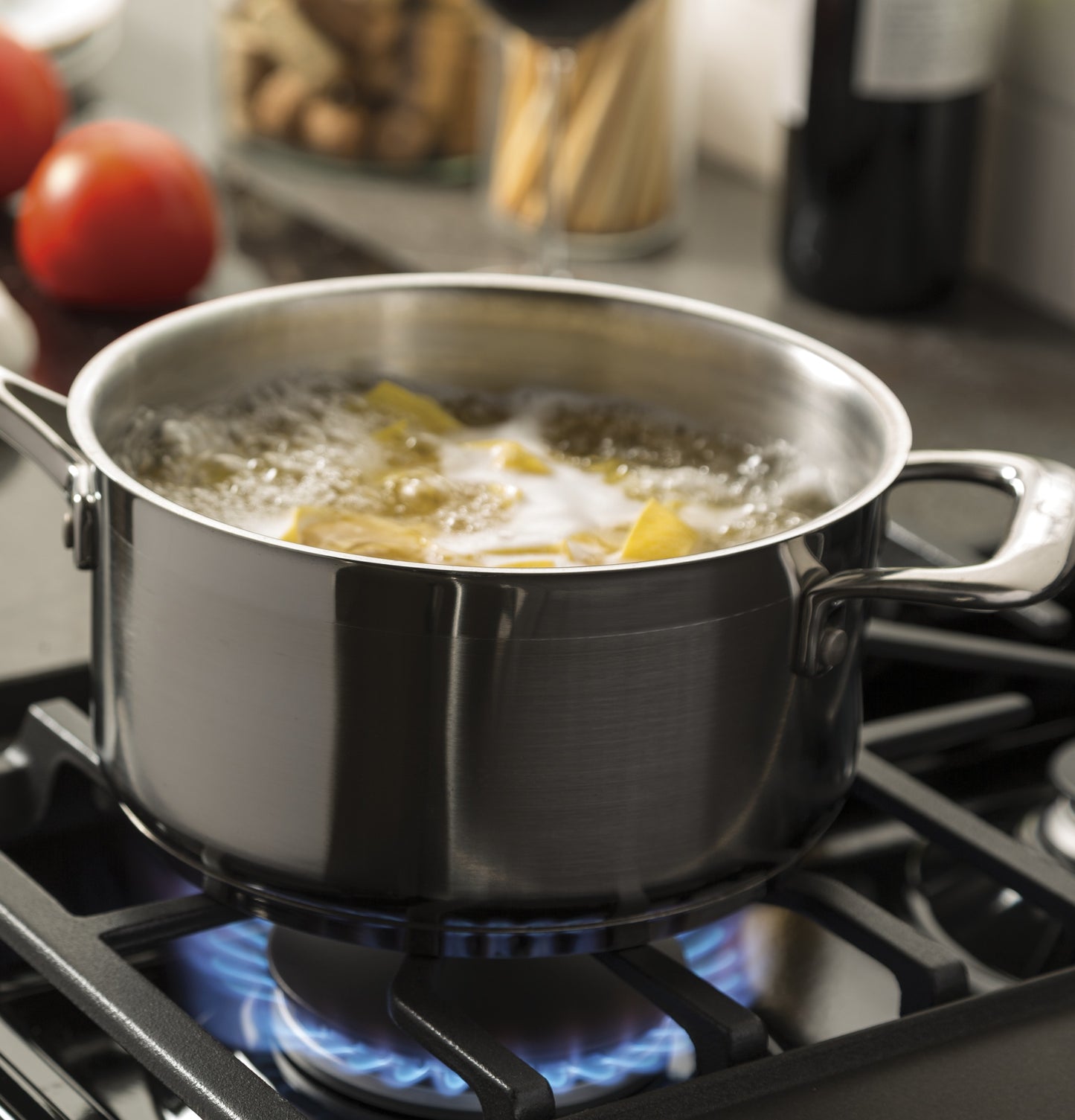 Stainless steel pot boiling water on a gas burner in kitchen appliances and gas ranges collection