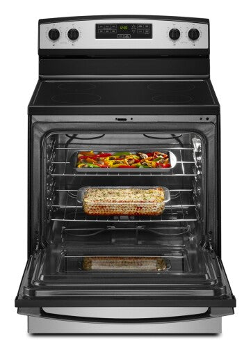 Front view of black and stainless steel electric range with smooth cooktop and open oven containing casserole dishes cooking meals