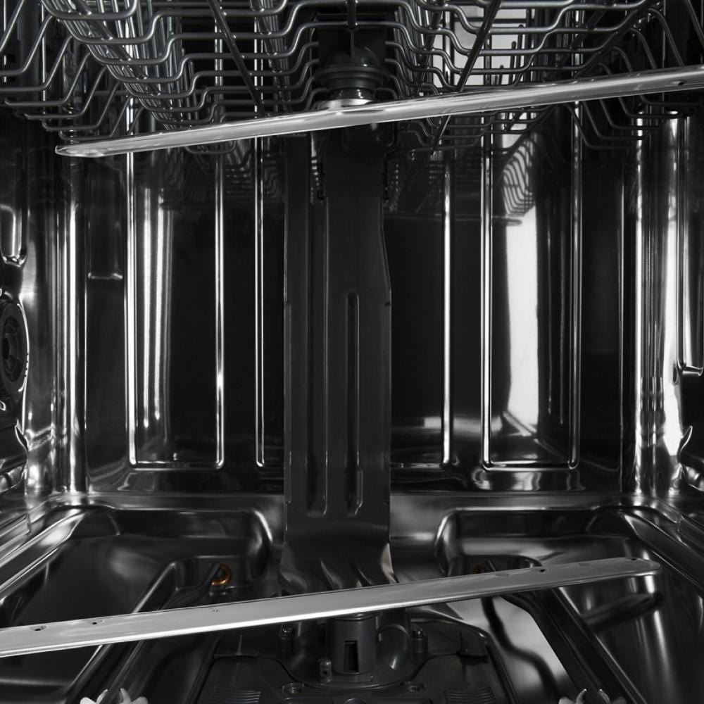 Interior view of stainless steel dishwasher showing spray arm and racks for dishes in kitchen appliances setting