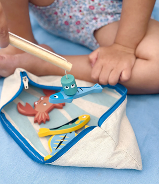 Child playing with wooden magnetic fishing toy in pretend play and Toys & Games collections under $50