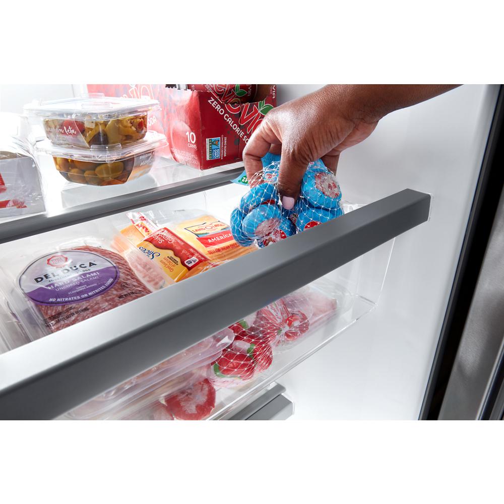 Hand placing bagged blue eggs in door bin of side-by-side refrigerator in Appliances and Kitchen collection