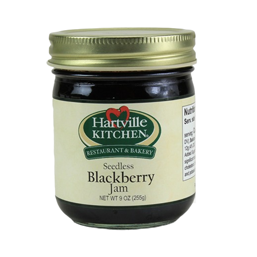 Glass jar of Hartville Kitchen seedless blackberry jam with metal gold lid for kitchen and pantry use