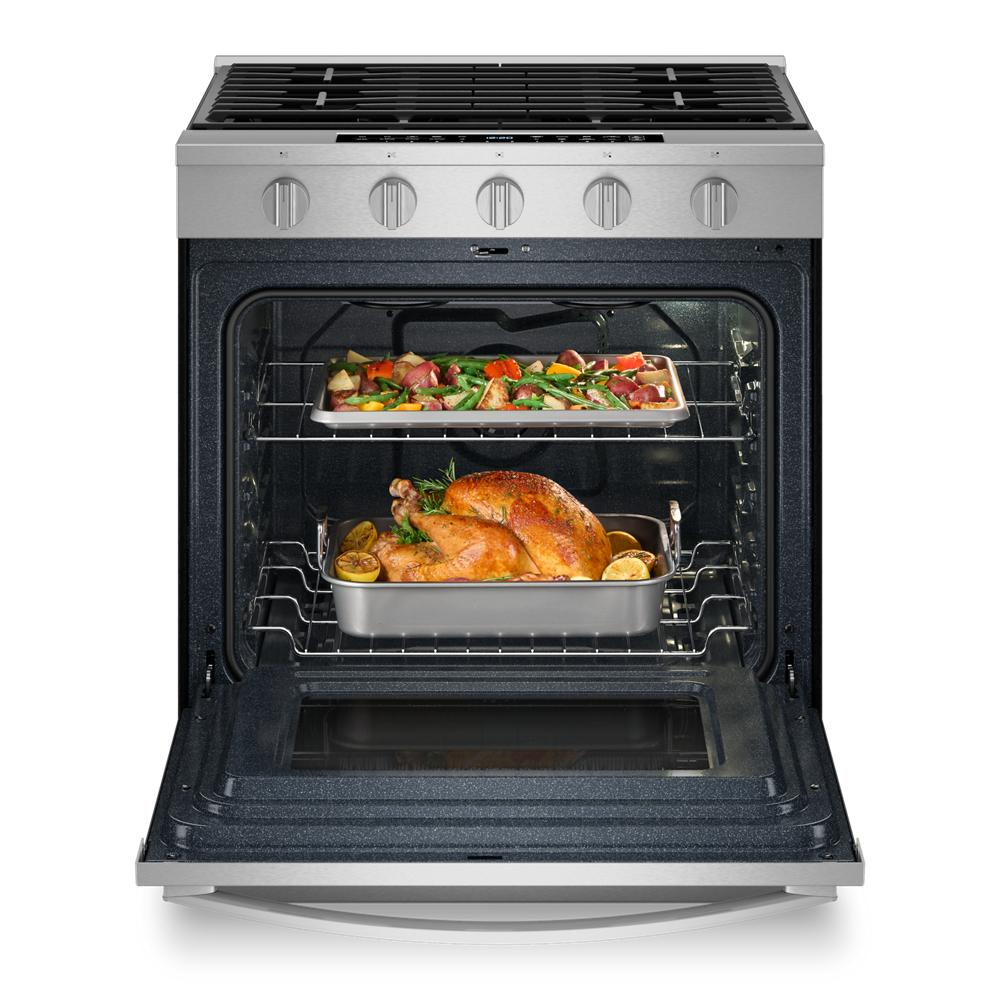 Stainless steel gas range with open oven door showing cooked chicken and vegetables inside for kitchen appliances use