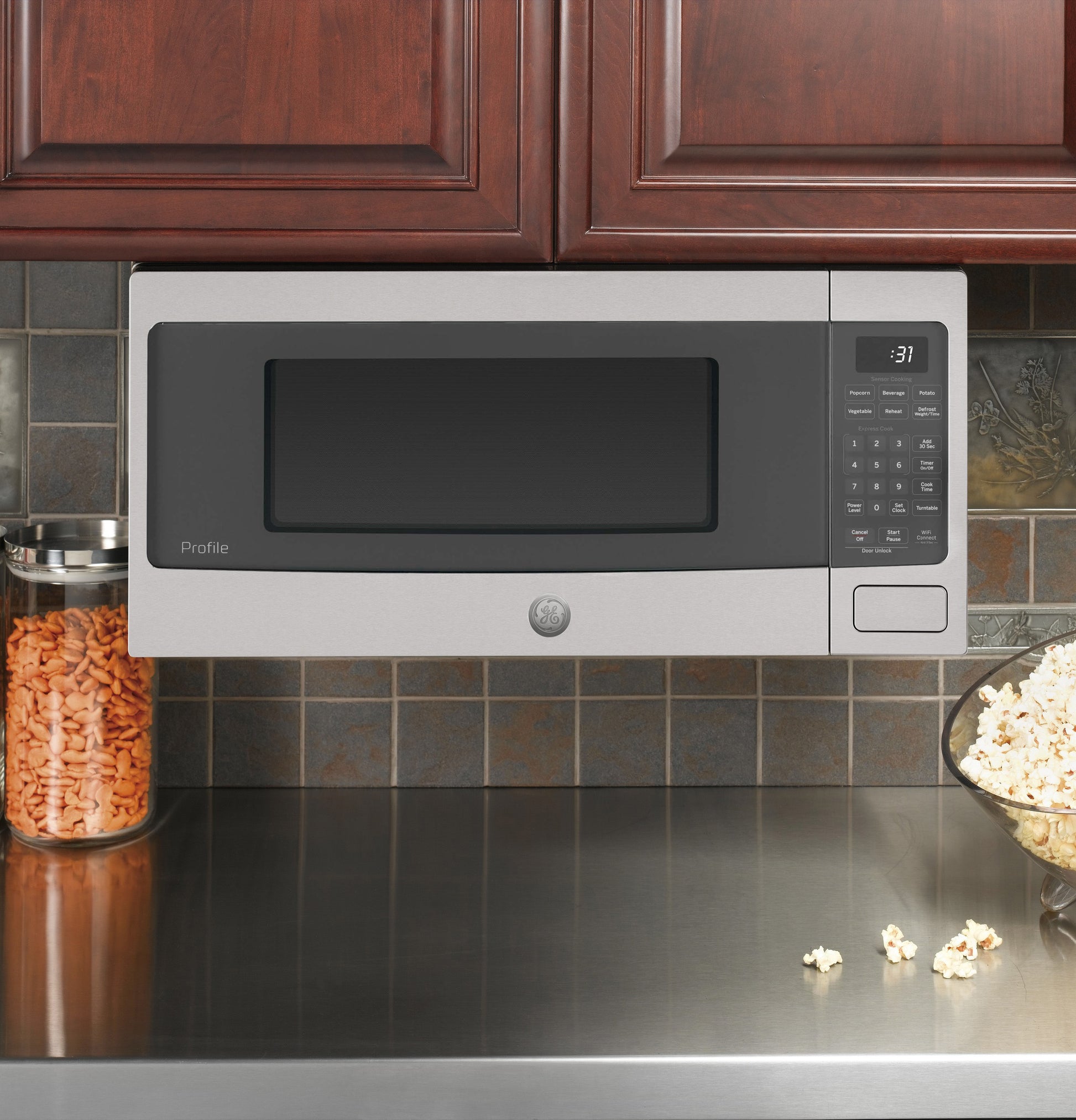 Stainless steel countertop microwave oven with digital keypad and dark window in kitchen appliances setting