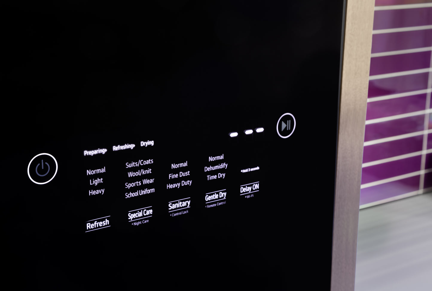 Control panel of Steam Closet with Fabric Refresh showing cycle options and delay start in black and stainless steel finish