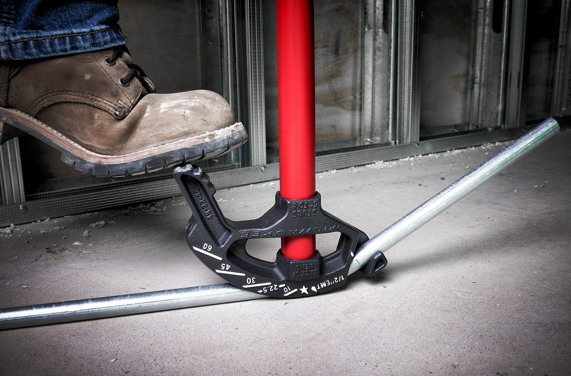 Heavy-duty iron conduit bender with high contrast angle markings in use on metal conduit for electrical tools collection