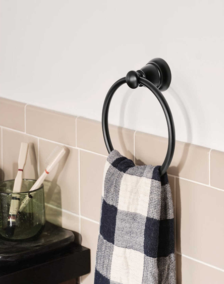 Matte black towel ring mounted on bathroom wall holding checkered towel in bathroom accessory setting