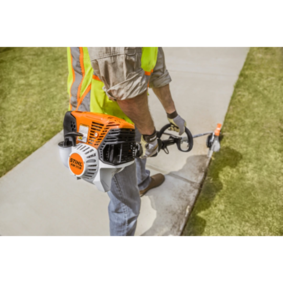 Worker operating a STIHL KM 111 R KombiMotor on a concrete edge for precise outdoor home improvement tasks