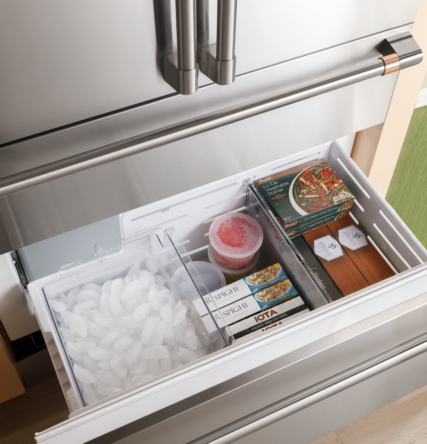 Stainless steel integrated bottom-freezer drawer with organized frozen meals and ice in kitchen appliances collection