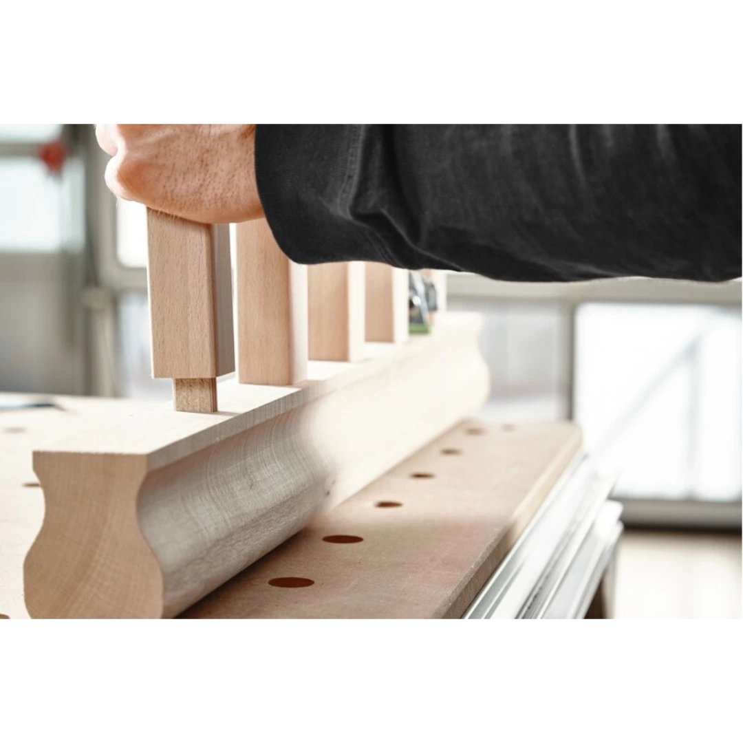 Hand fitting Beech wood tenon into mortise joint on woodworking bench with natural light in workshop setting